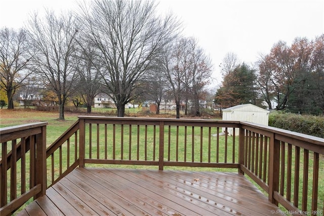 wooden deck featuring a yard and a storage unit