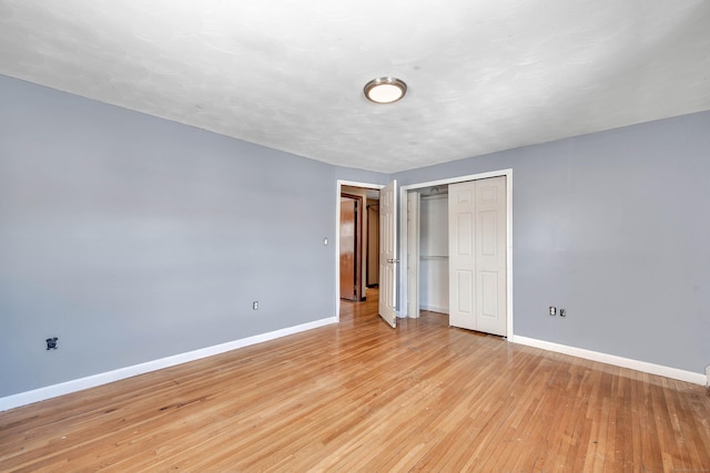 unfurnished bedroom featuring light hardwood / wood-style floors and a closet