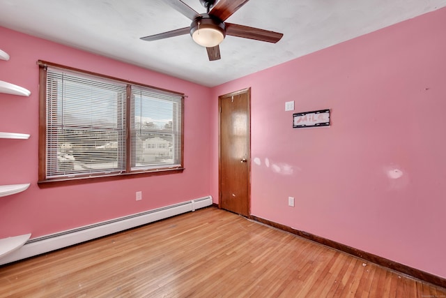 empty room with baseboard heating, ceiling fan, and light hardwood / wood-style flooring