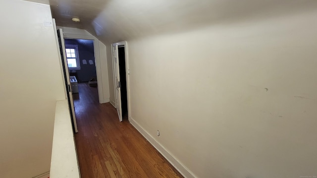 hall featuring dark hardwood / wood-style flooring and vaulted ceiling