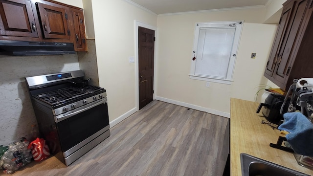 kitchen with crown molding, dark brown cabinetry, and stainless steel range with gas cooktop