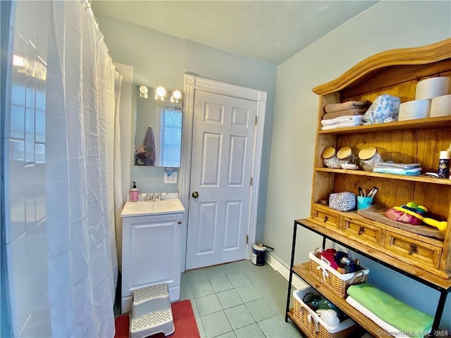 bathroom with tile patterned flooring, vanity, and walk in shower