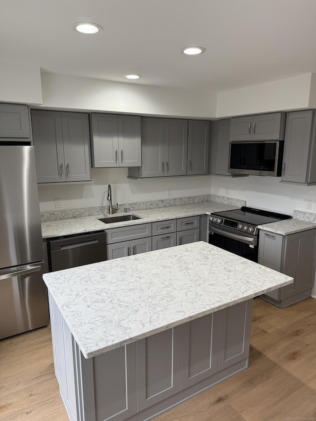 kitchen with sink, gray cabinets, a center island, and appliances with stainless steel finishes