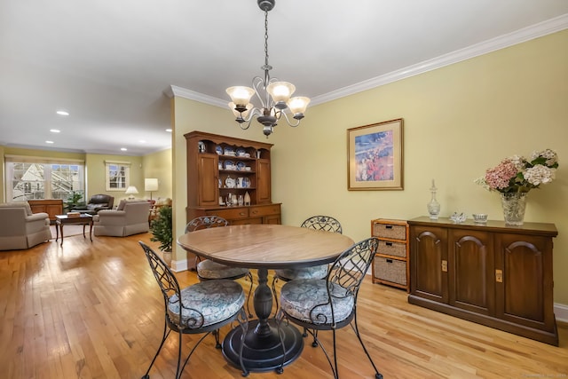 dining space featuring an inviting chandelier, crown molding, and light hardwood / wood-style floors