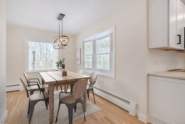 dining space with an inviting chandelier, baseboard heating, and light hardwood / wood-style floors