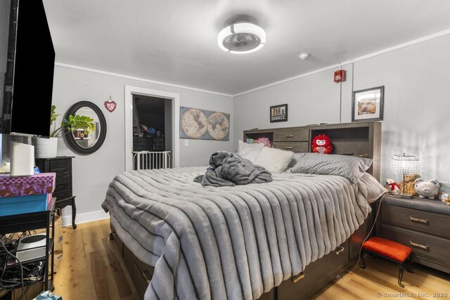 bedroom with light hardwood / wood-style flooring and ornamental molding