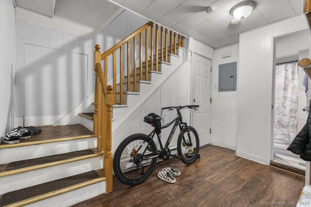 stairway with hardwood / wood-style floors and electric panel