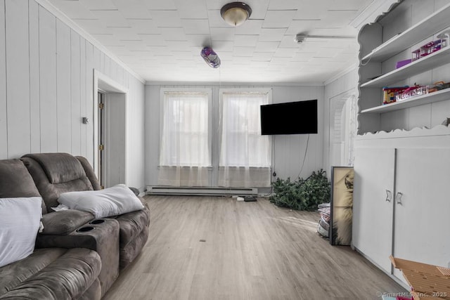 living room with ornamental molding, a baseboard heating unit, and light wood-type flooring