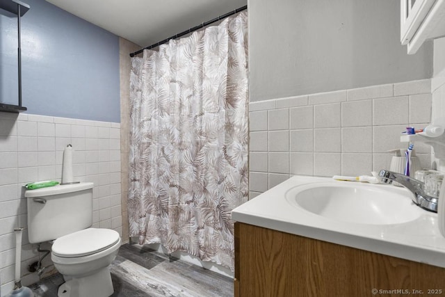 bathroom featuring hardwood / wood-style flooring, tile walls, vanity, curtained shower, and toilet