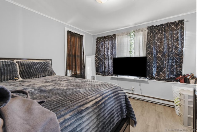 bedroom featuring baseboard heating, ornamental molding, and light wood-type flooring