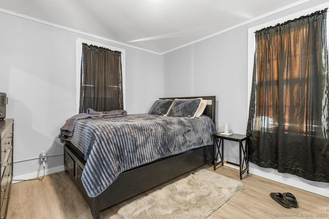 bedroom featuring ornamental molding and light hardwood / wood-style flooring