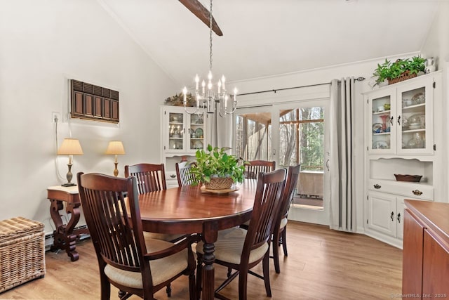 dining room with high vaulted ceiling, a chandelier, and light hardwood / wood-style floors