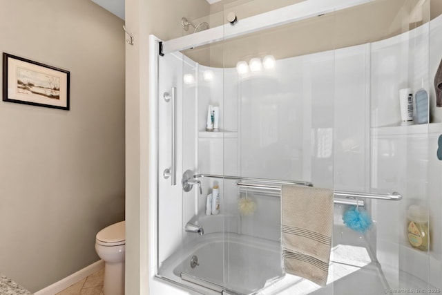 bathroom featuring tile patterned flooring, toilet, and combined bath / shower with glass door