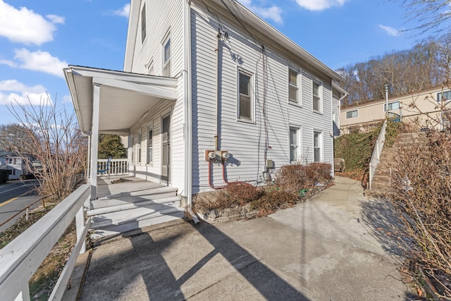 view of side of property featuring covered porch