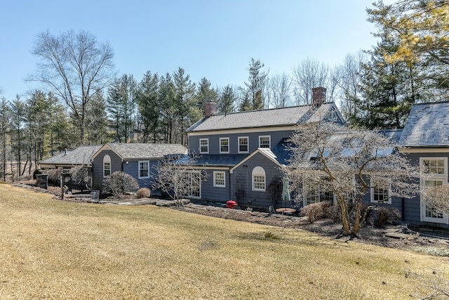 view of front of home featuring a chimney and a front yard