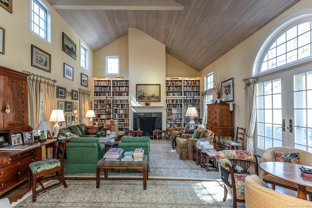 living area with a towering ceiling, french doors, wooden ceiling, and a fireplace