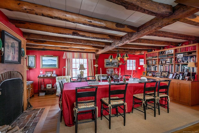 dining room with plenty of natural light, beam ceiling, and wood finished floors