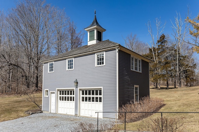 view of home's exterior featuring an attached garage, fence, and a lawn