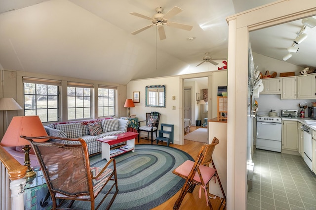 living room with a toaster, rail lighting, ceiling fan, and vaulted ceiling