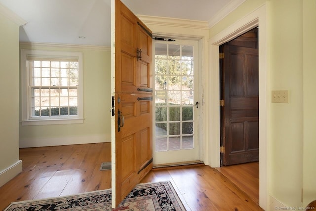 entryway featuring crown molding and light hardwood / wood-style flooring