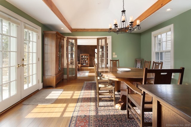 dining space with french doors, a chandelier, light wood-type flooring, and a wealth of natural light