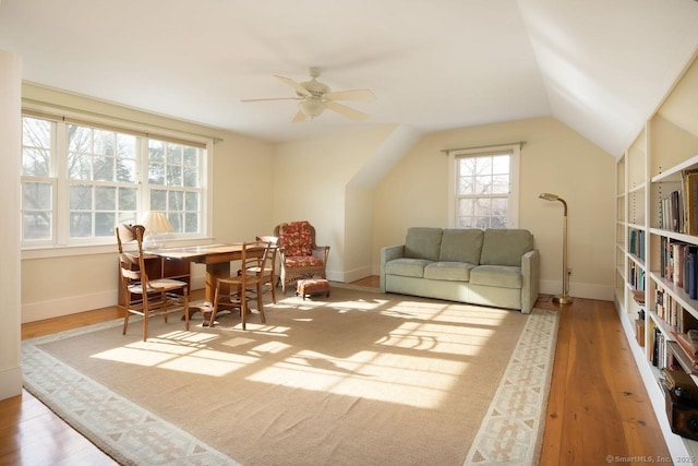 living room with lofted ceiling, ceiling fan, and light hardwood / wood-style flooring