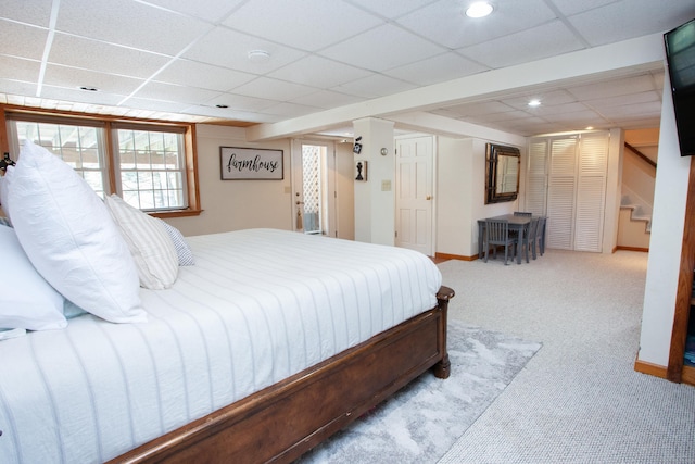 bedroom featuring light colored carpet and a drop ceiling