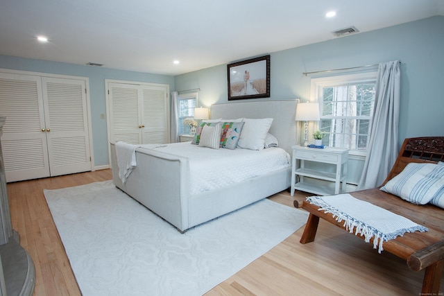 bedroom featuring two closets and hardwood / wood-style flooring