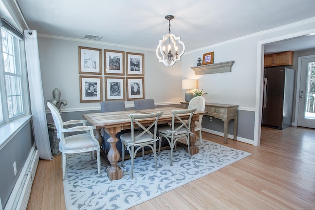 dining area with baseboard heating, ornamental molding, a chandelier, and light wood-type flooring