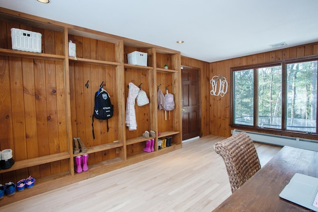 mudroom with a baseboard heating unit, wood walls, and light wood-type flooring