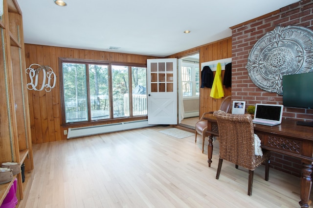 office space with wooden walls, light hardwood / wood-style flooring, and a baseboard heating unit