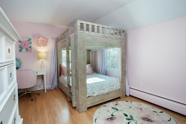 bedroom with light wood-type flooring and baseboard heating