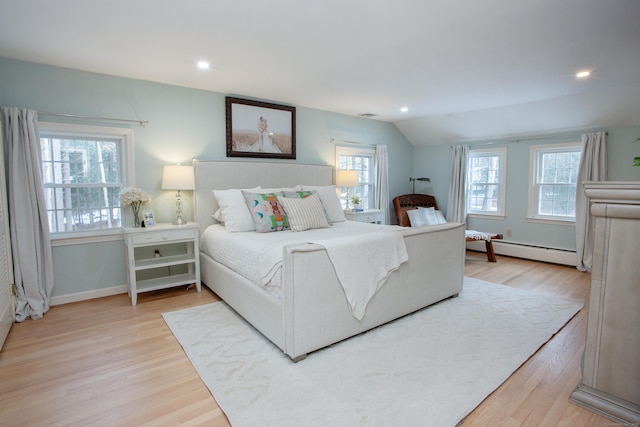 bedroom featuring wood-type flooring, vaulted ceiling, and baseboard heating