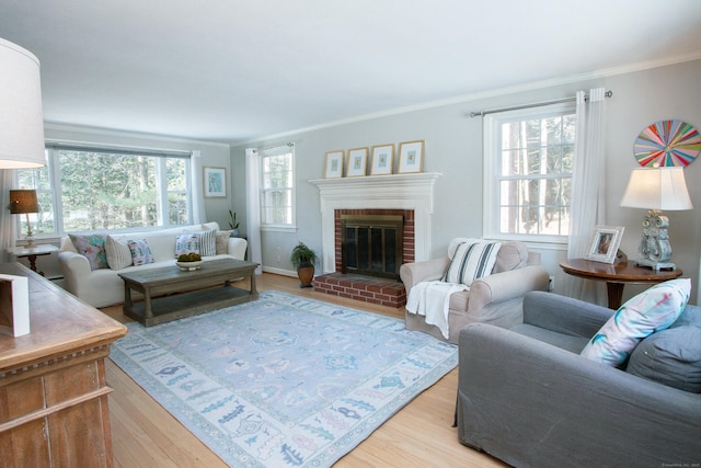 living room with crown molding, a fireplace, and light wood-type flooring