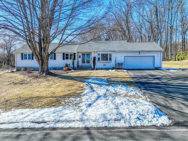 ranch-style home with a garage and a front lawn