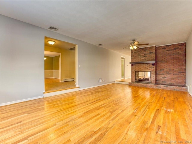 unfurnished living room with light hardwood / wood-style flooring, a baseboard heating unit, a fireplace, and ceiling fan