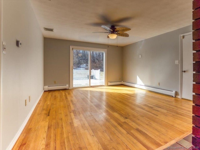 empty room with ceiling fan, light wood-type flooring, and a baseboard heating unit