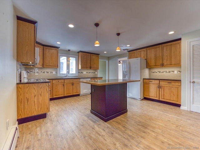 kitchen with pendant lighting, white appliances, tasteful backsplash, light hardwood / wood-style floors, and a kitchen island