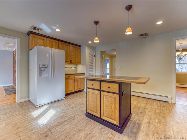 kitchen with baseboard heating, a center island, white refrigerator with ice dispenser, decorative light fixtures, and light wood-type flooring