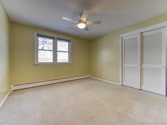 unfurnished bedroom featuring a baseboard heating unit, light colored carpet, a closet, and ceiling fan