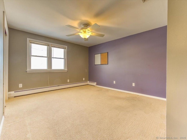 carpeted spare room featuring baseboard heating and ceiling fan