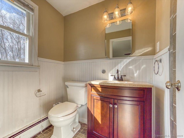 bathroom featuring vanity, a baseboard heating unit, and toilet