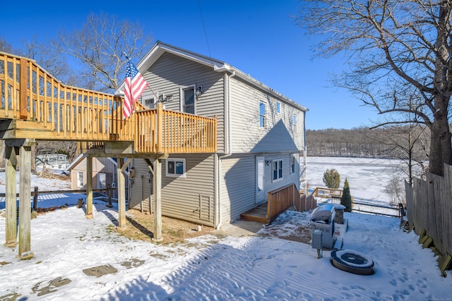 snow covered house featuring a wooden deck