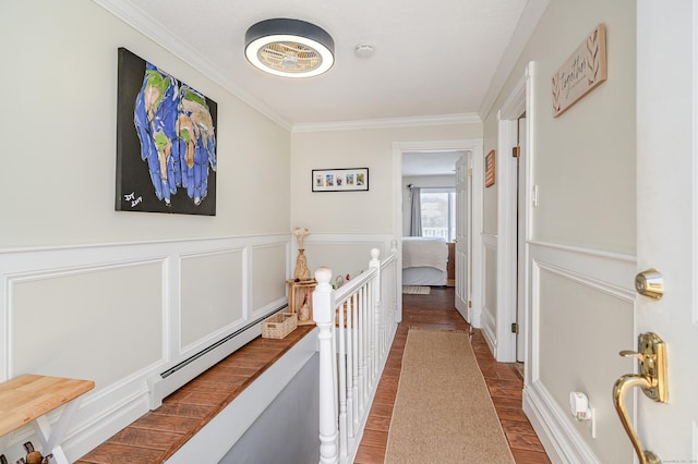 corridor featuring hardwood / wood-style flooring, ornamental molding, and a baseboard radiator