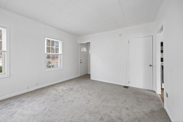 carpeted empty room featuring crown molding and a wealth of natural light