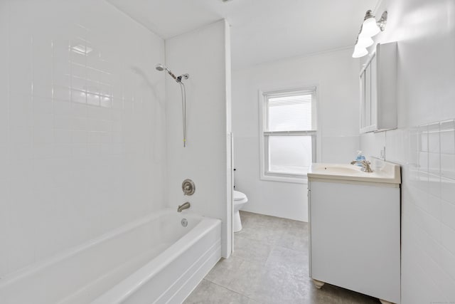 full bathroom featuring vanity, tiled shower / bath, tile walls, and toilet