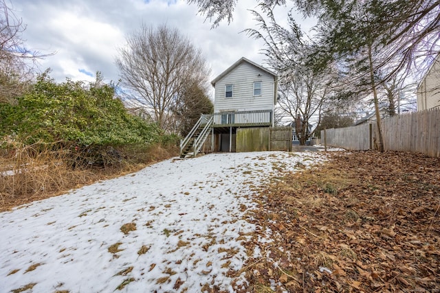 snow covered rear of property featuring a wooden deck