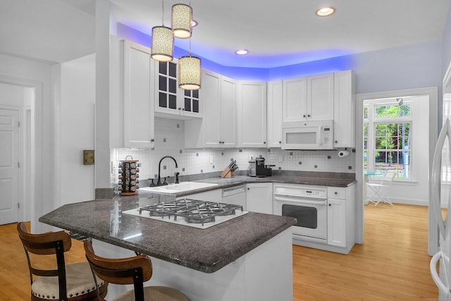 155 W Rd, East Haddam, CT 06420 - kitchen featuring a peninsula, white cabinets, white appliances, a kitchen breakfast bar, and recessed lighting