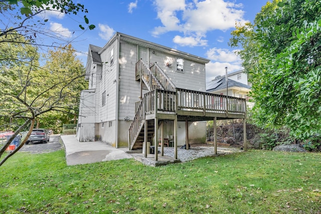 rear view of house with a wooden deck and a lawn