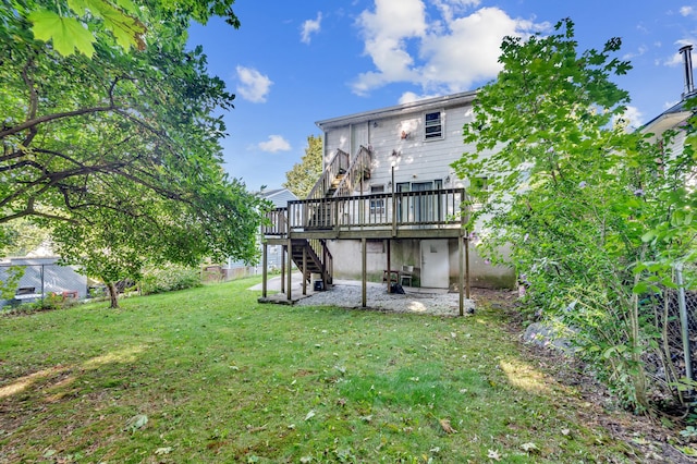 rear view of property with a wooden deck and a lawn